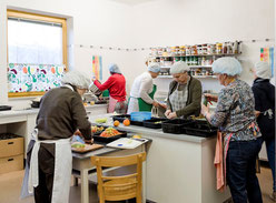 6 Frauen Kochhauben beim Einkochen in einer Küche